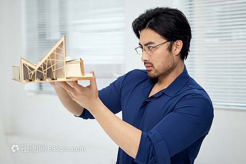 建筑設(shè)計(jì)師手拿建筑模型研究